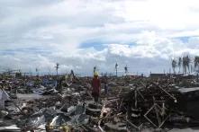 A man stands surrounded by the devastation wrought by Typhoon Haiyan in the city of Tacloban.jpg