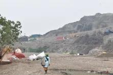 A waste worker walking towards the Ghazipur landfill, third round in a day looking for plastics to sell