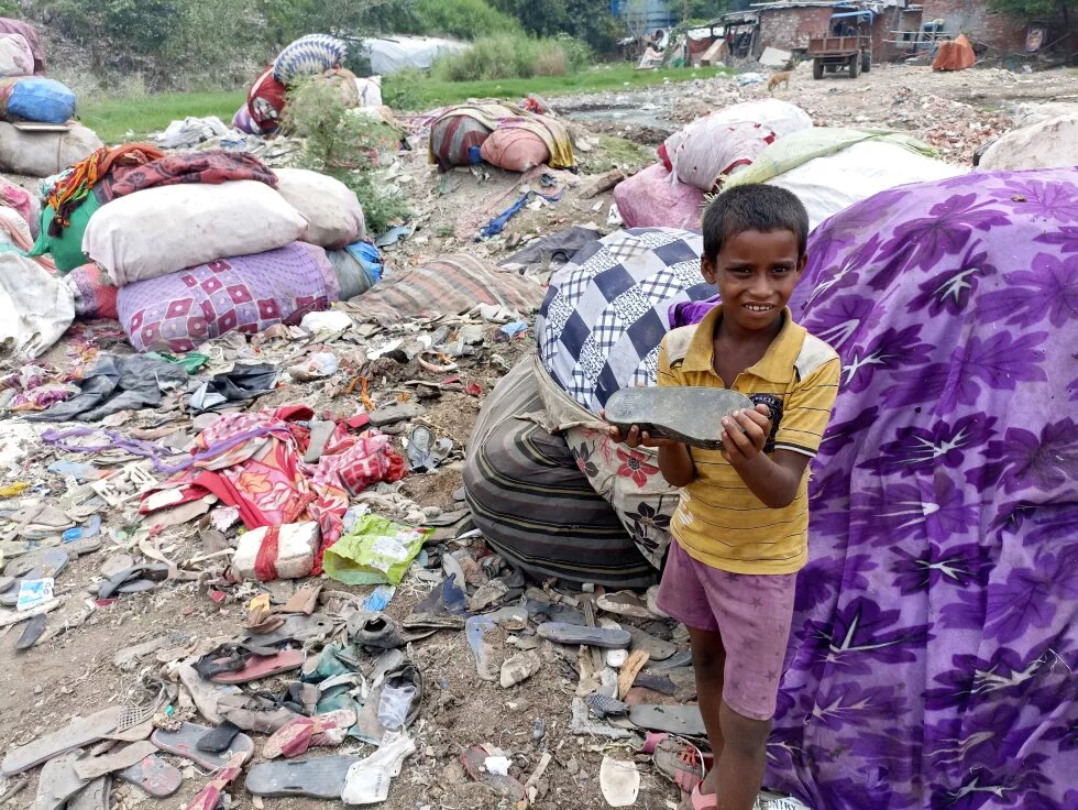 A 13-year-old boy picks up a plastic and rubber slipper to show me how durable they are.