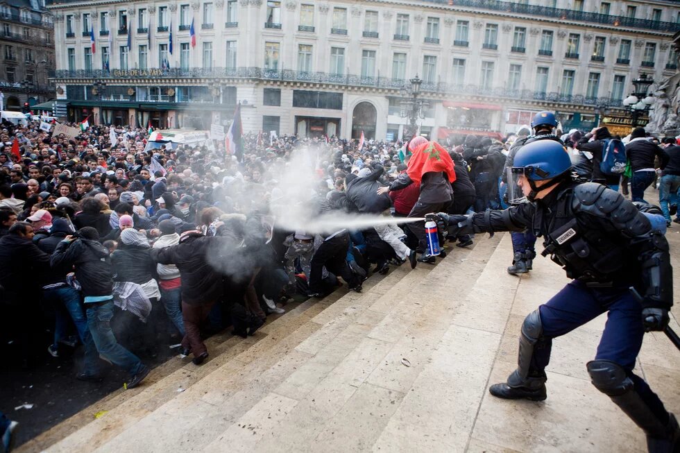 Policeman uses pepper spray against protesters in France.